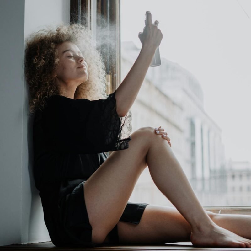 woman in black dress sitting on window